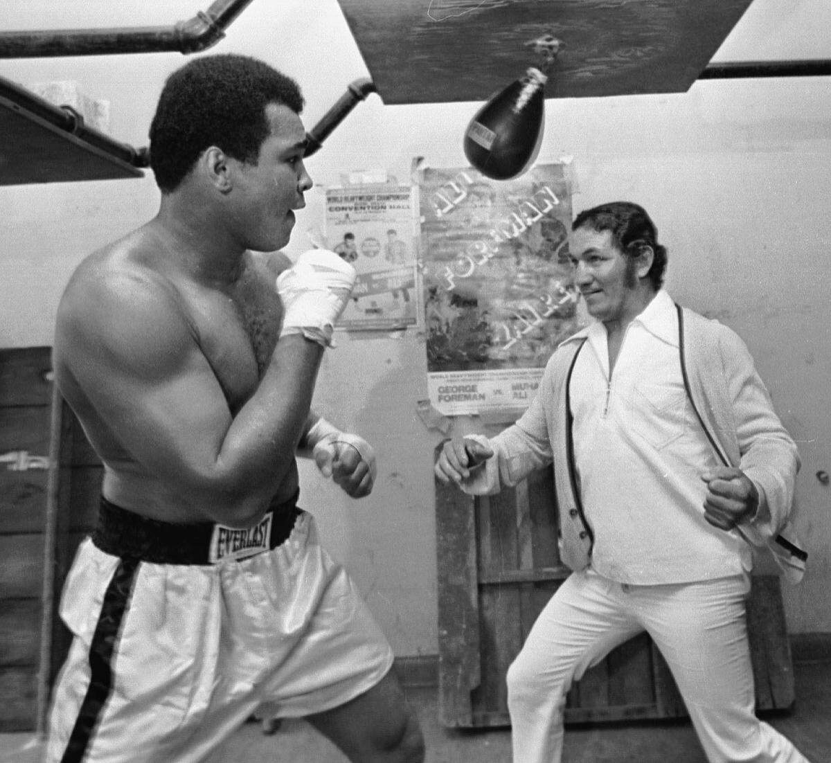 Ali plays with middle weight Florentino Fernandez a fighter who carried the most powerful left hook in boxing during his time. Photo from the late 1960s.