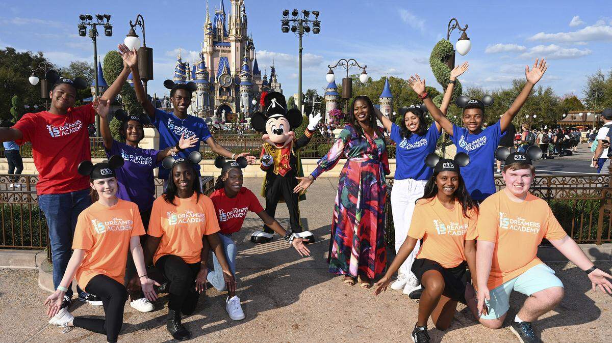 Drum Major Mickey Mouse (center) and Disney Dreamers Academy Executive Champion Tracey D. Powell welcomes several students from the Disney DreamersAcademy Class of 2022 at Magic Kingdom.