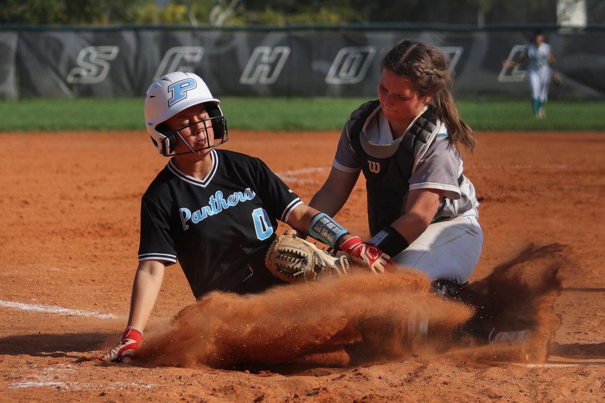 Coral Reef’s catcher Char Diedrick (10) tags Palmetto’s Gracie Silberberg (0) out at home plate during the seventh inning of the Greater Miami Athletic Conference softball final on Thursday, April 20, 2023, at Coral Reef High School in Richmond Heights, Fla. Coral Reef won 5-2.