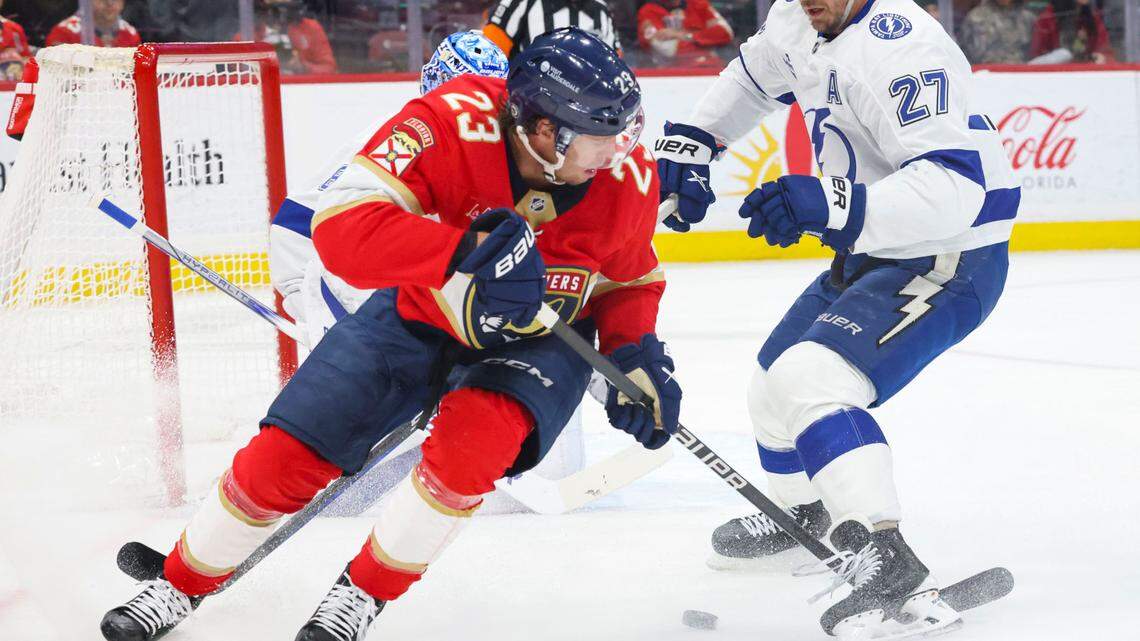 Florida Panthers center Carter Verhaeghe (23) loses the puck after Tampa Bay Lightning defenseman Ryan McDonagh (27) loses his stick pushes him during the first period of a game on Monday, March 3, 2025, at Amerant Bank Arena in Sunrise, Fla.