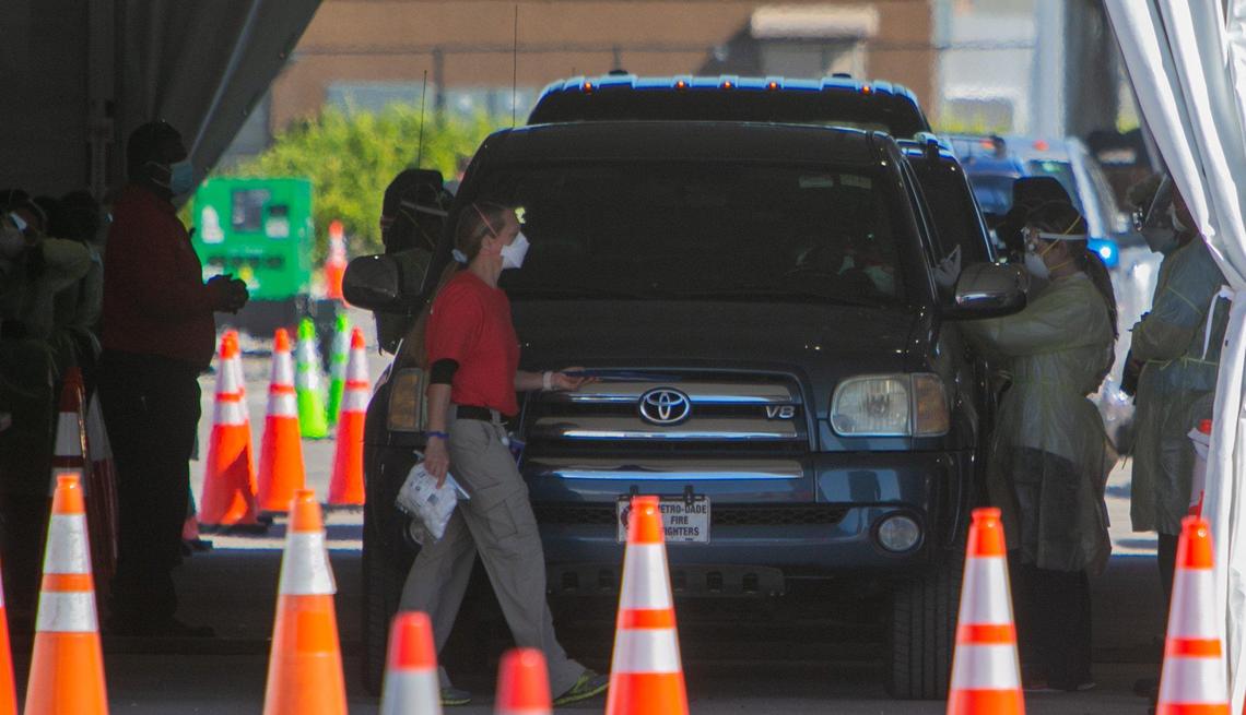 A health worker can be seen administering a vaccine to a person inside his vehicle at the Hard Rock Stadium site in Miami Gardens on Jan. 6, 2021. Gov. Ron DeSantis announced that Hard Rock Stadium was officially a site where those who qualify can get their COVID-19 vaccination.