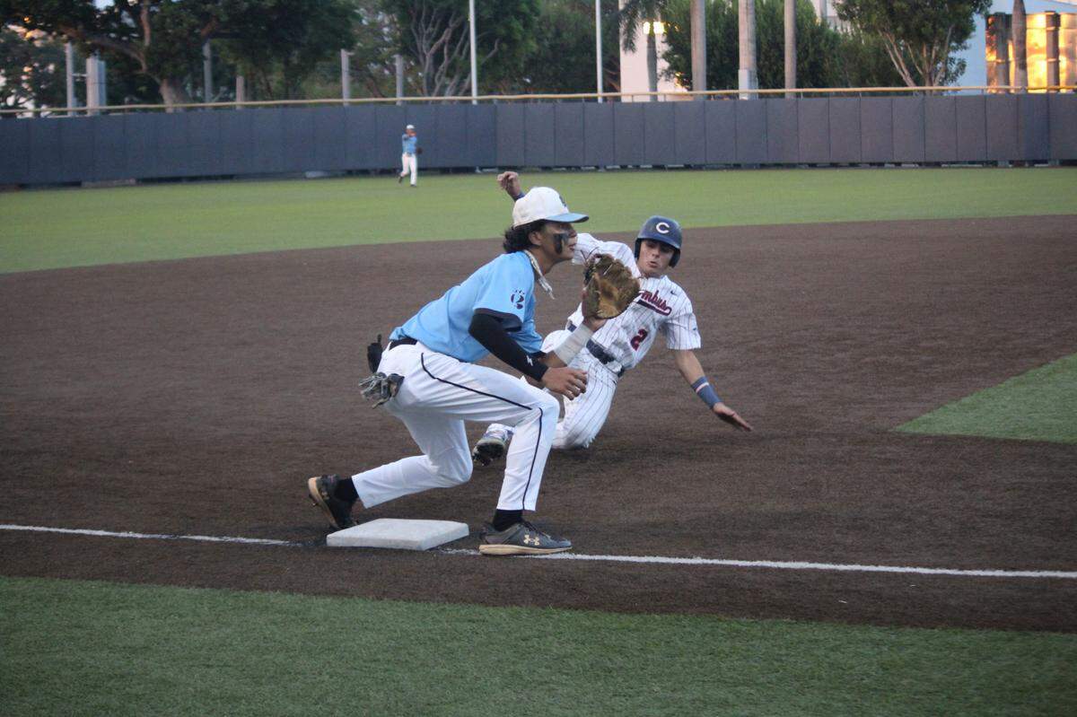 Columbus left fielder Luis Miguel slides in safely under the tag of West Broward third baseman AJ Cruz during Saturday’s Region 4-7A semifinal game at Columbus.