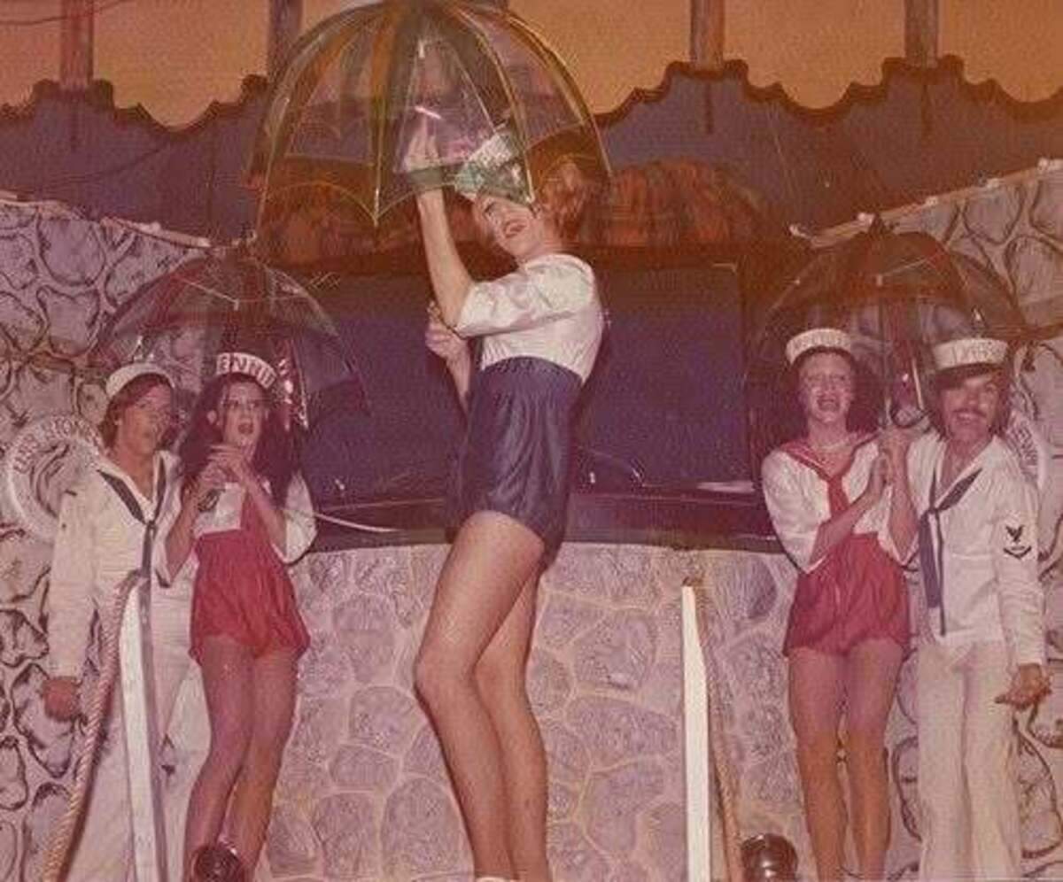Performers grin under umbrellas at the Stonewall Discotheque in 1972, an LGBTQ+ nightclub in Miami Beach.