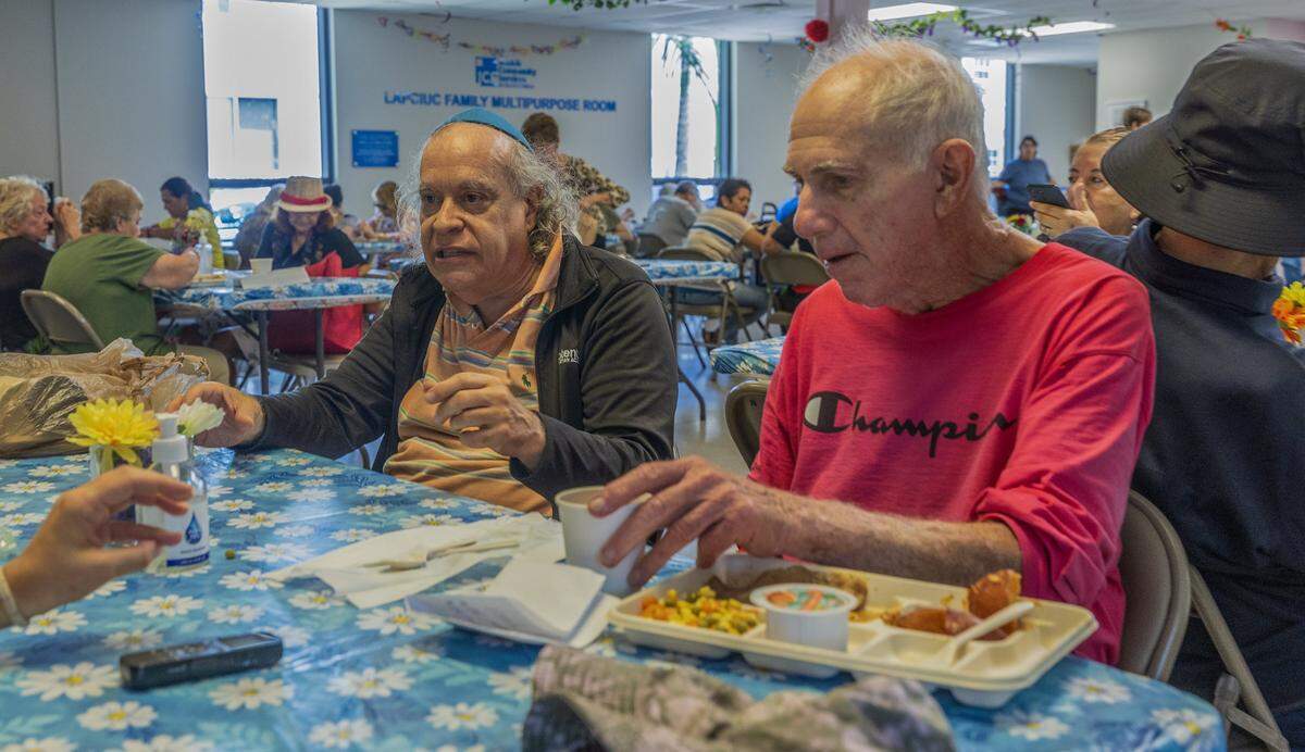 Members Baruch Cohn (left) and Joel Louis shared during lunch time at the Diener JCS Family Center in Miami Beach, where members received many services including lunch, entertainment, etc all year round that could be affected as JCS is one of over 40 nonprofits that's losing significant funds ($16 million) due to Miami-Dade County budget cuts, on Tuesday, August 12, 2025.