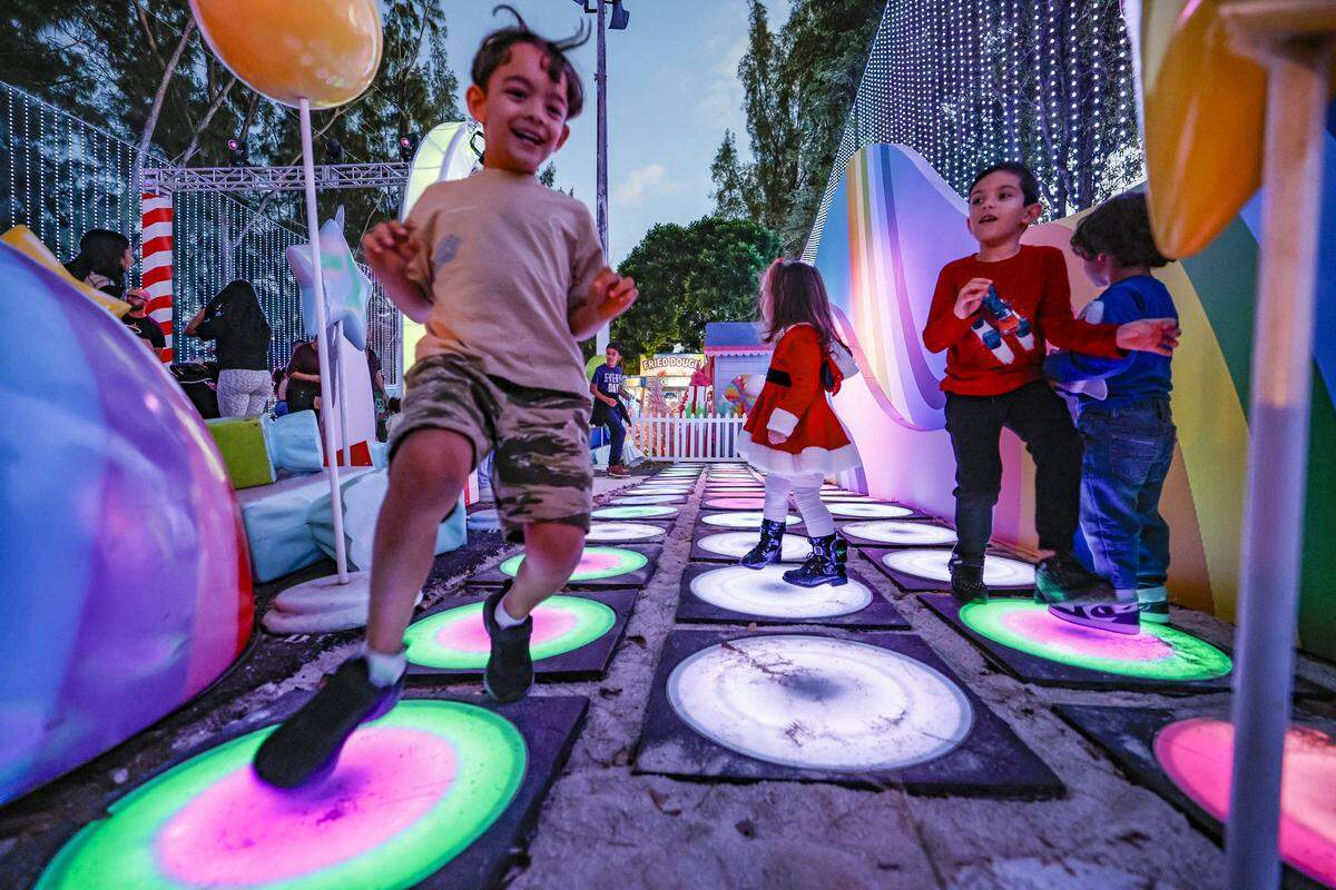 Children play along Rainbow Road at Christmas Wonderland at Tropical Park, a Miami-style holiday celebration of flavor and culture in Miami, Florida on Thursday, November 13, 2025.