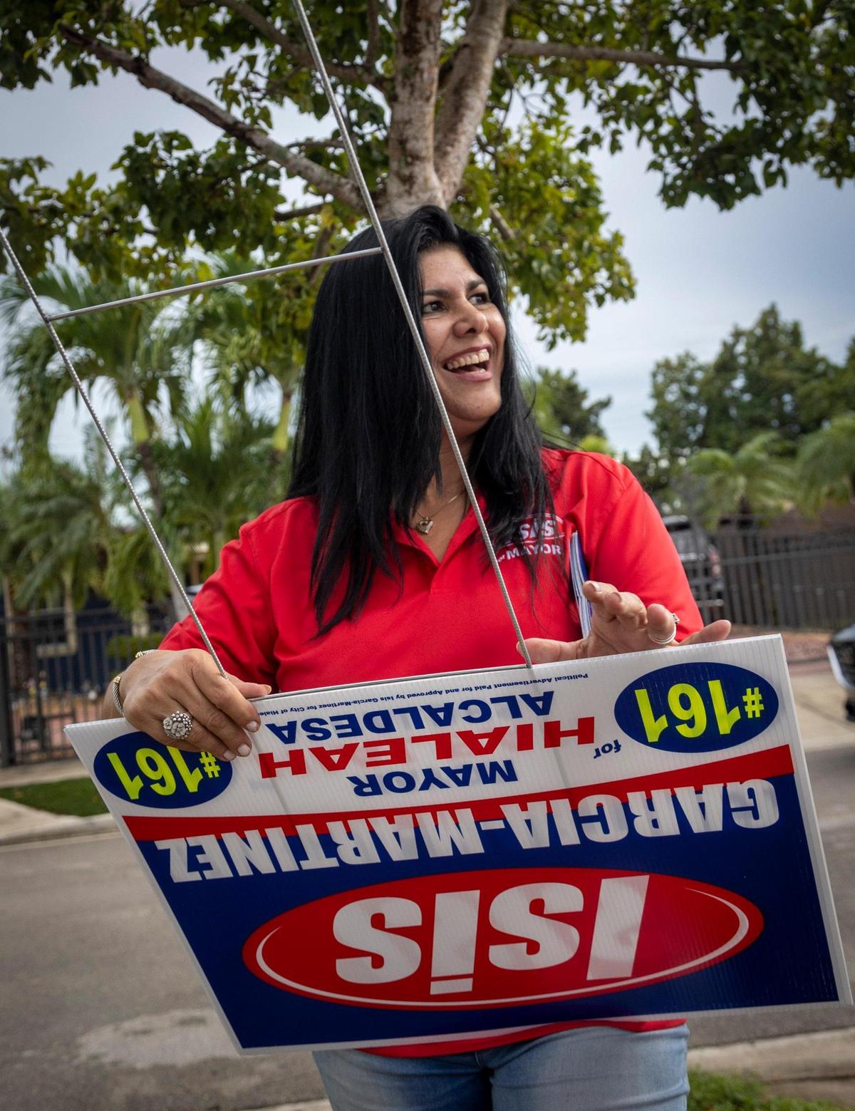 Hialeah mayoral candidate Isis Garcia-Martinez prepares a sign for a neighbor in Hialeah on Sept. 24, 2021.