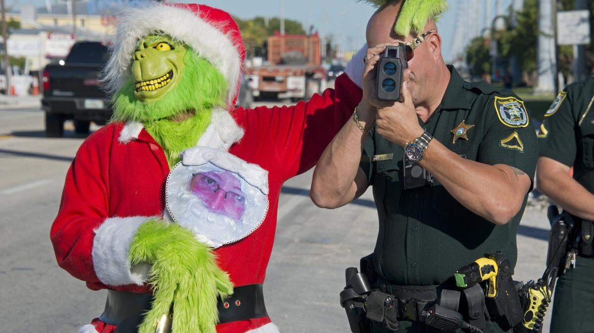 Monroe County Sheriff’s Office Col. Lou Caputo, left, has some fun with Deputy Willie Guerra as he aims a radar speed gun in a school zone on the Florida Keys Overseas Highway Tuesday, Dec. 12, 2017, in Marathon.