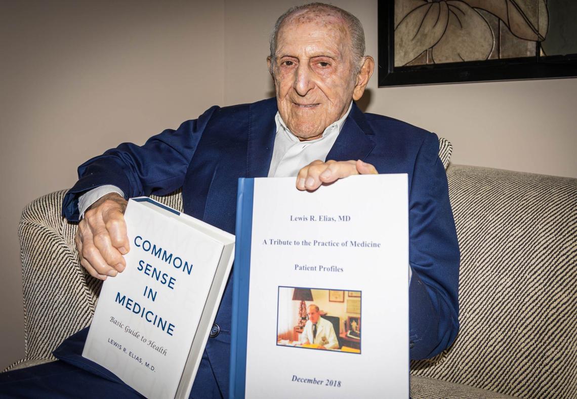Lewis Elias, 98, holds his own book ‘Common Sense in Medicine’ and a compilation book gifted to him by his son Jamie at his sister Virginia’s house on Saturday, August 3, 2024 in Coral Gables, Fla.