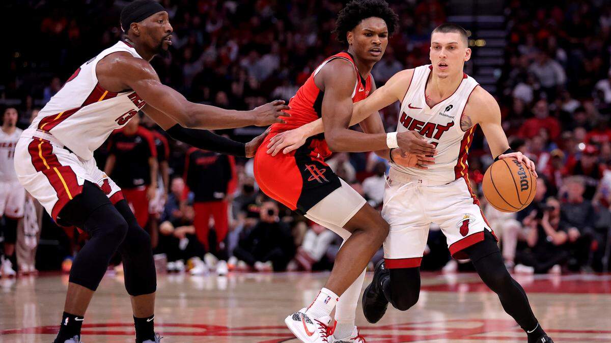 El defensa de los Miami Heat, Tyler Herro (14), maneja el balón contra el defensa de los Houston Rockets, Amen Thompson (1), durante el cuarto cuarto en el Toyota Center.