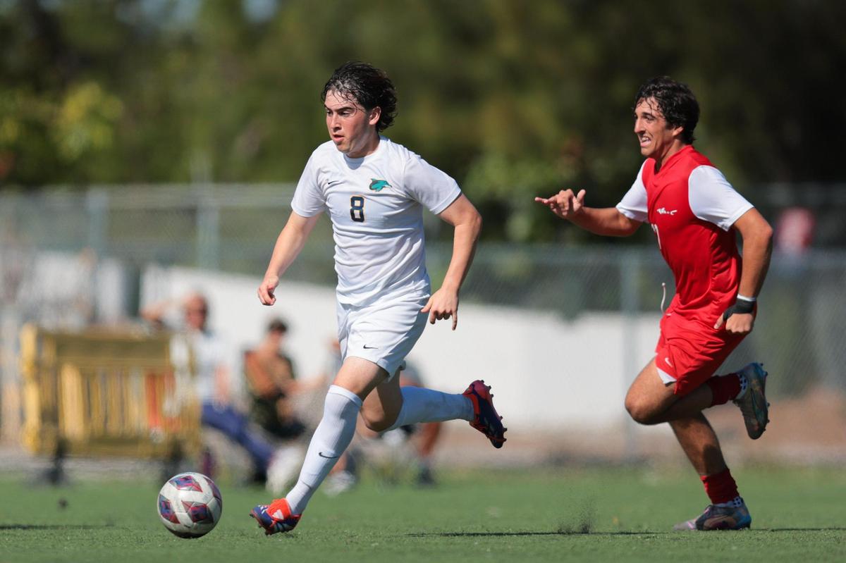 Downtown Doral forward Santiago Ramos (8) runs with the ball past MAST Academy midfielder Jaime Uriburu (17) during the second half of a boys soccer Region 4-3A quarterfinal playoff game at MAST Academy in Miami, Florida, Tuesday, February 11, 2025.