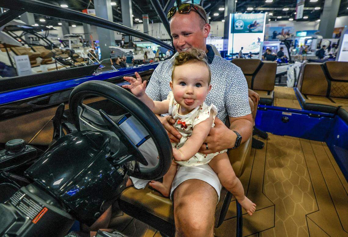 Jake Nazarian and his daughter Natalie, 8 months, tour a boat on display at the Miami Beach International Boat Show in the Miami Beach Convention Center on Miami Beach, Florida on Thursday, February 12, 2026 