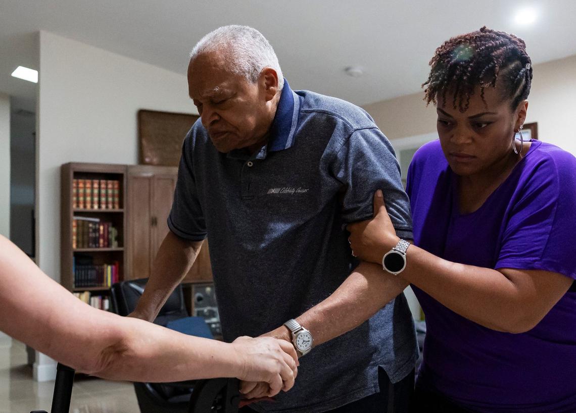 Krystal Adderley, 40, helps her father, David Lawrence Adderley, 86, walk at their home in Miami-Dade on Thursday, Aug. 29, 2024.