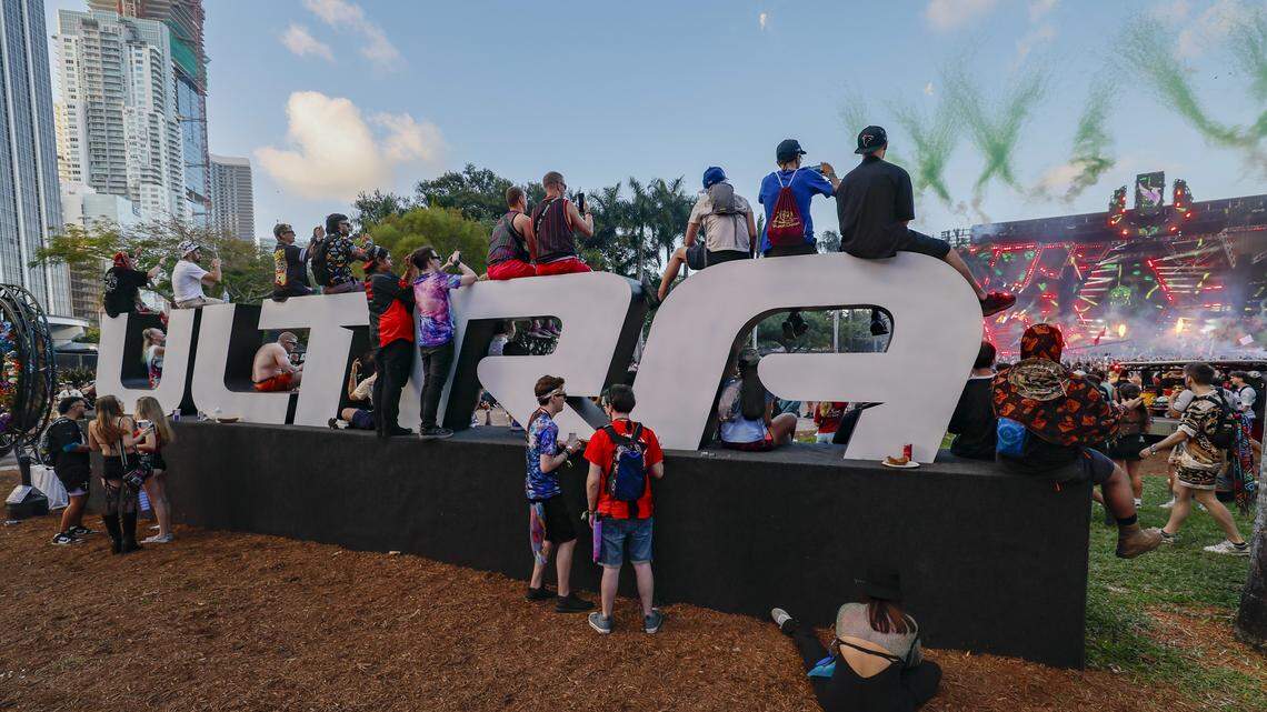 EDM fans sit on the Ultra name display near the main stage at Ultra Music Festival in Miami on Friday, March 27, 2026.