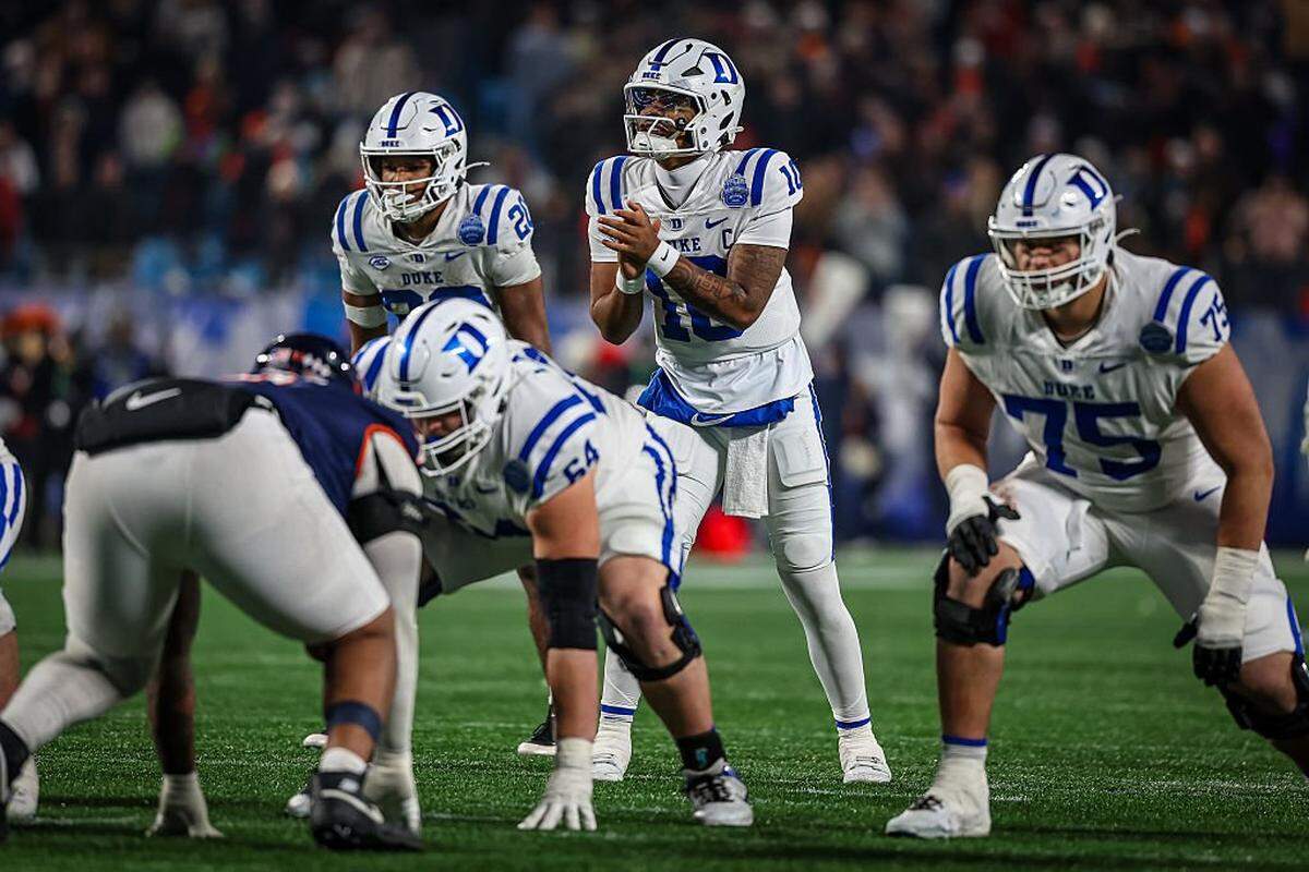 CHARLOTTE, NORTH CAROLINA - DECEMBER 06: Darian Mensah #10 of the Duke Blue Devils snaps the ball during overtime in the 2025 ACC Football Championship against the Virginia Cavaliers at Bank of America Stadium on December 06, 2025 in Charlotte, North Carolina. (Photo by David Jensen/Getty Images)