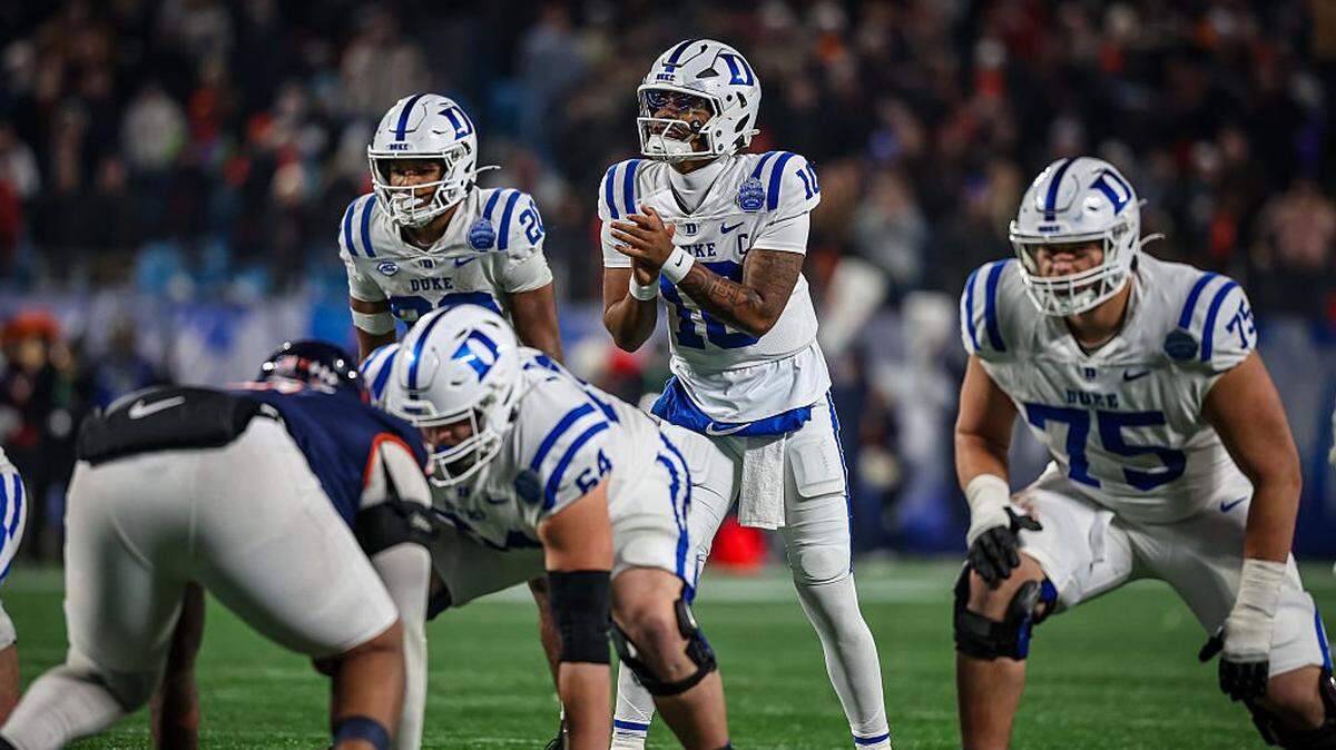 CHARLOTTE, NORTH CAROLINA - DECEMBER 06: Darian Mensah #10 of the Duke Blue Devils snaps the ball during overtime in the 2025 ACC Football Championship against the Virginia Cavaliers at Bank of America Stadium on December 06, 2025 in Charlotte, North Carolina. (Photo by David Jensen/Getty Images)