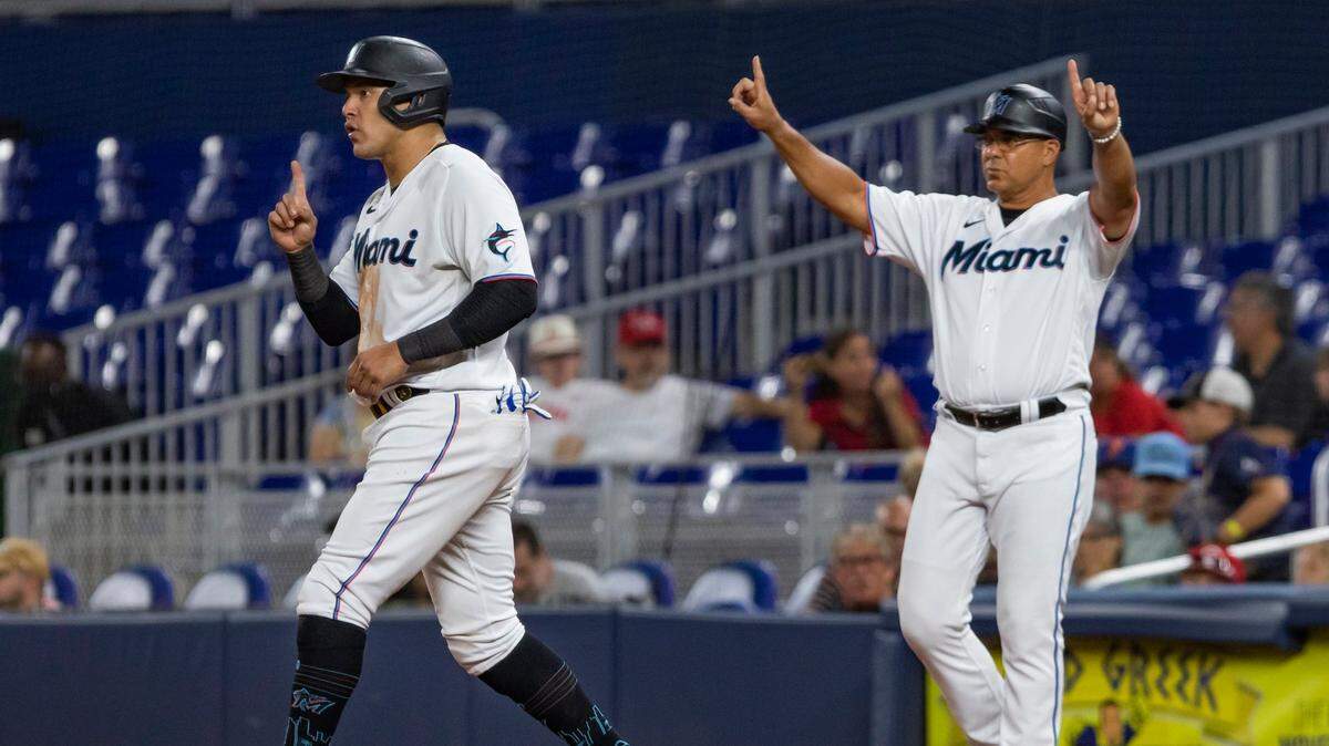 Miami Marlins right fielder Avisail Garcia (24) (left) and Miami Marlins first base coach Keith Johnson (88) are seen during the ninth inning of a MLB game against the Cincinnati Reds at loanDepot park in Miami, Florida on Monday, August 1, 2022.