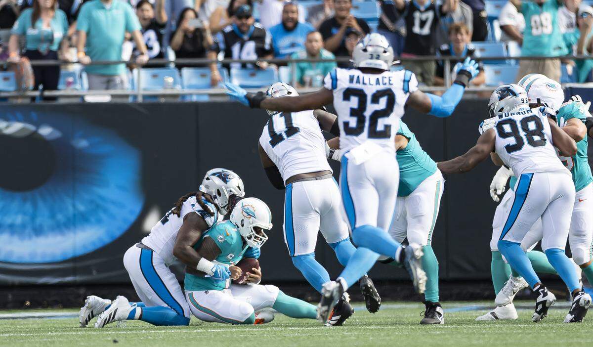 Carolina Panthers linebacker Patrick Jones II (91) tackles Miami Dolphins quarterback Tua Tagovailoa (1) in the second half of their NFL game at the Bank of America Stadium on Sunday, Oct. 5, 2025, in Charlotte, N.C.