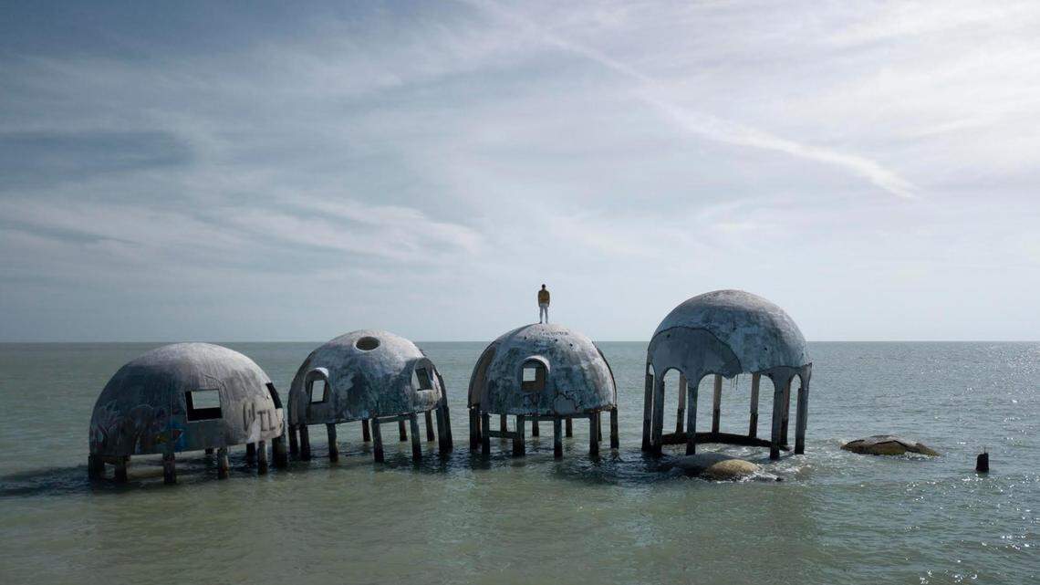 British artist Simon Faithfull stands atop one of the almost-submerged structures of Dome House near Marco Island.
