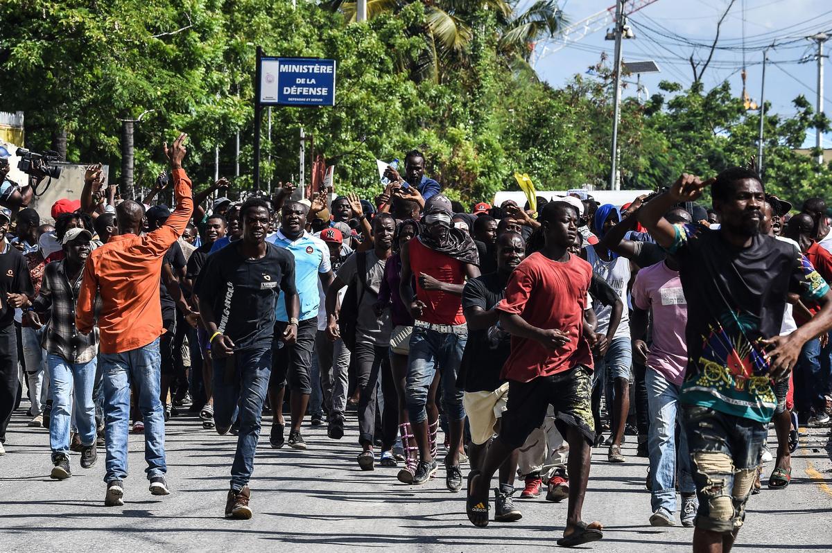 Demonstrators march on the street near parliament as they protest against the ruling government in Port-au-Prince, on September 23, 2019.
