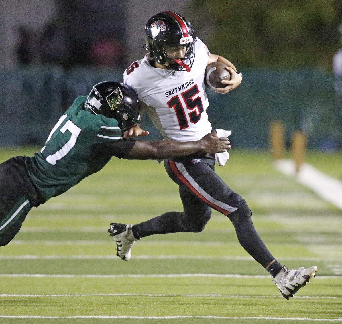 Southridge Spartans quarterback James Perrone (15) attempts evade a tackle by Miami Central Rockets linebacker Luisden Paul during football game on Saturday, October 18, 2025 at Traz Powell Stadium in Miami. Andrew Uloza / for Miami Herald
