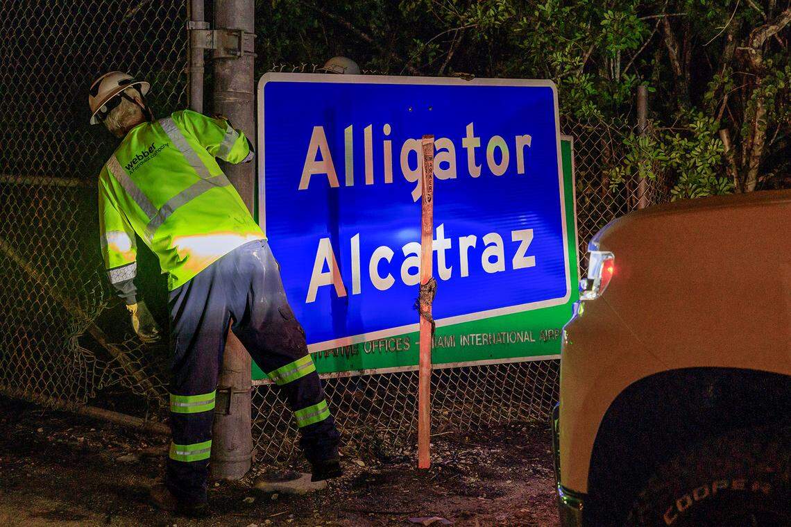 Two workers finished covering the Dade-Collier Training and Transition Airport with the “Alligator Alcatraz,” sign at the entrance of the migrant detention center, in Ochopee, Florida on Wednesday July 02, 2025.