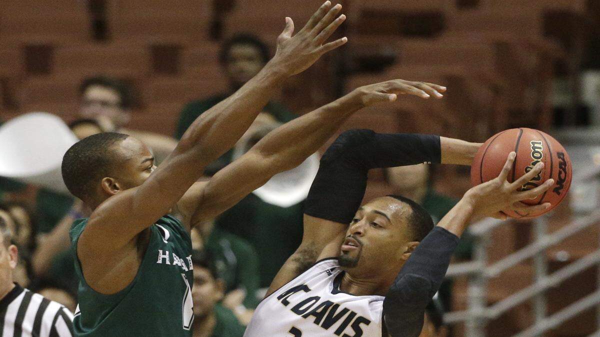 UC Davis' Corey Hawkins, right, is defended by Hawaii's Garrett Nevels during the first half of an NCAA college basketball game in the semifinals of the Big West Conference 