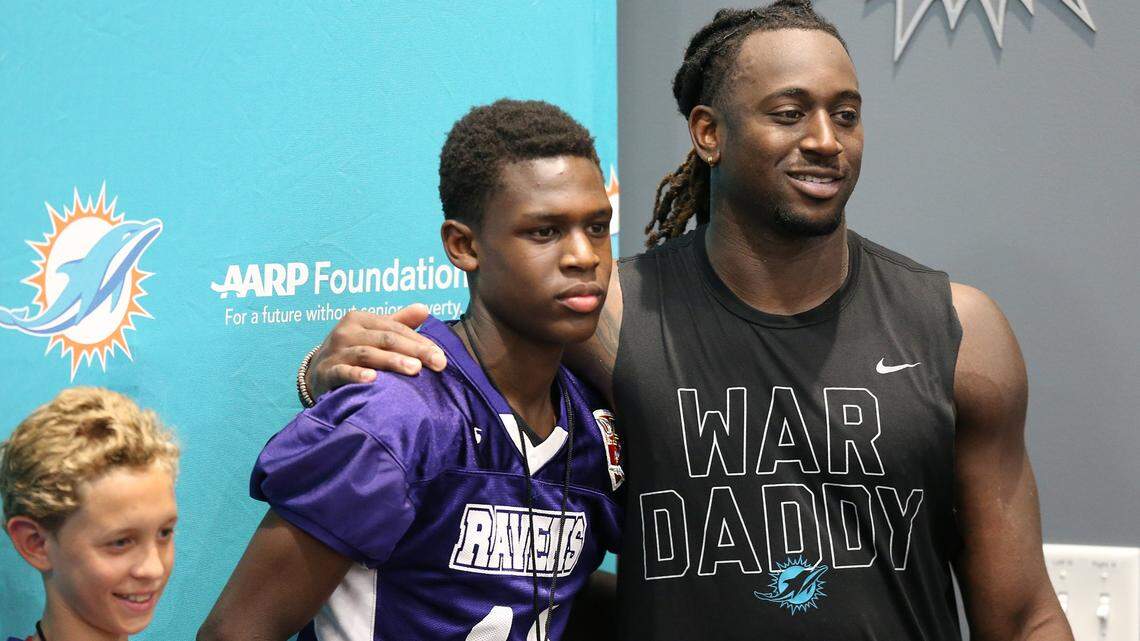 Cornerback Walt Aikens poses with Jason Meronne, 14, from the North Miami Beach PAL program following Dolphins practice Tuesday.