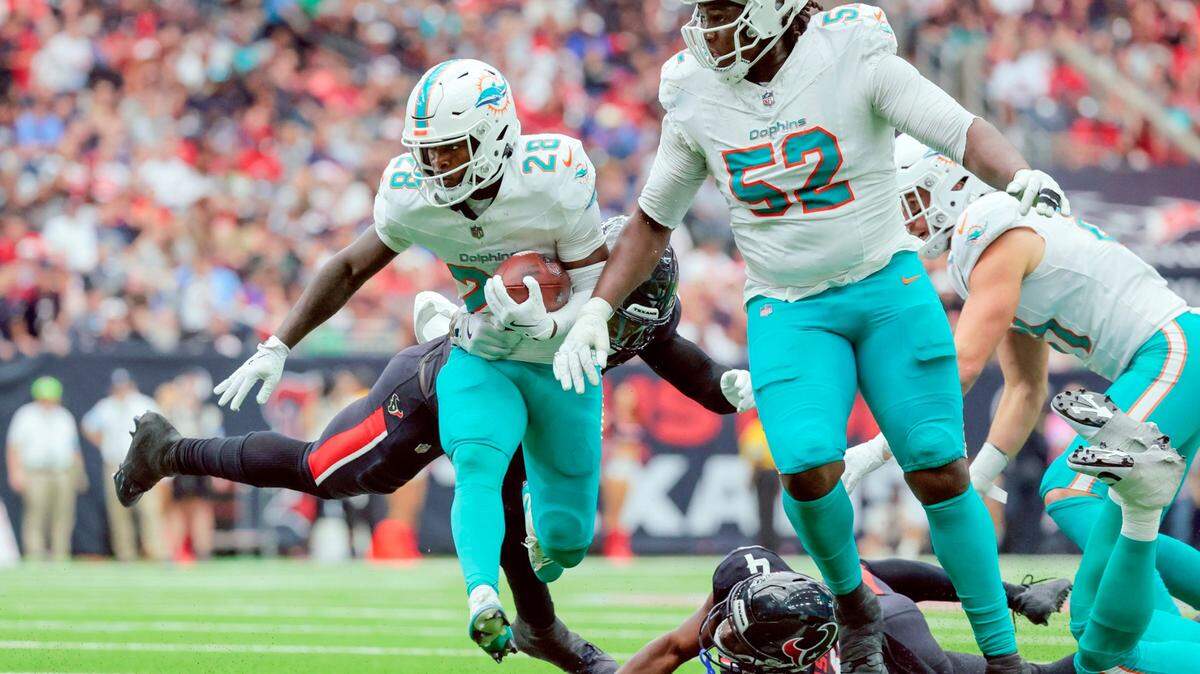 Miami Dolphins offensive tackle Patrick Paul (52) sets up to block as running back De’Von Achane (28) carries the ball in the first half of their NFL football game against the Houston Texans at NRG Stadium in Houston, Texas, on Sunday, December 15, 2024.