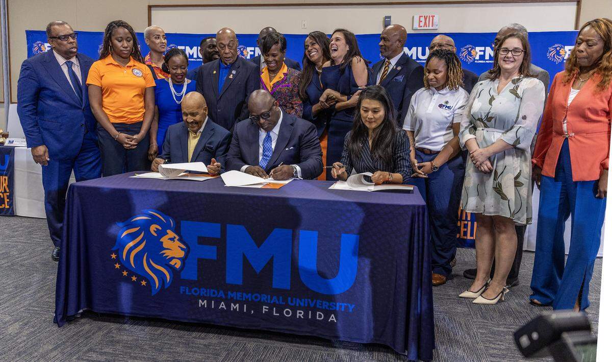 Officials and guests surrounded from left- Horace Hord, Chairman of the FMU Foundation, William C. McCormick, Jr. President of the Florida Memorial University and Joy Andrews St. Johns County Administrator as they sign a historic lease agreement between FMU and St. Johns County that paves the way for Florida's first Black History Museum - to be built on the sacred ground where the university was founded.” at Florida Memorial University in Miami Gardens, on Friday October 17, 2025.
