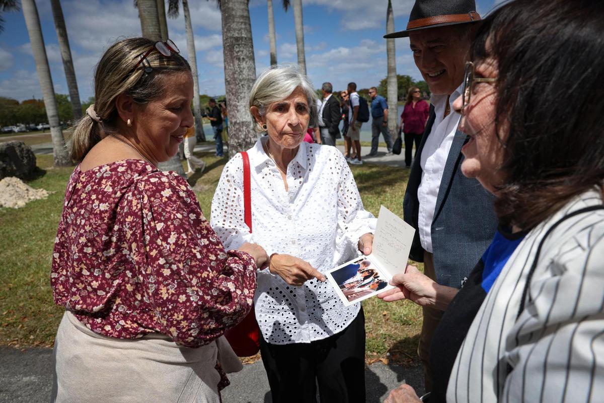 Silvia Unzueta, center, a Women’s Park founder, and Luisa Maria Guell, right, look at a photo of them from the time capsule mural 31 years ago during an unveiling ceremony on Wednesday, March 22, 2023, at The Women’s Park in Miami. The time capsule was buried in 1992 and was supposed to be dug up on the 100th anniversary of women’s suffrage but got delayed due to COVID-19.