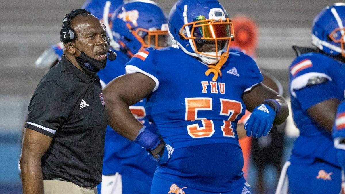 Coach Tim Ice Harris Sr. stands with players of the Florida Memorial University’s football team scrimmage at Traz Powell Stadium in Miami on Friday, April 16, 2021.