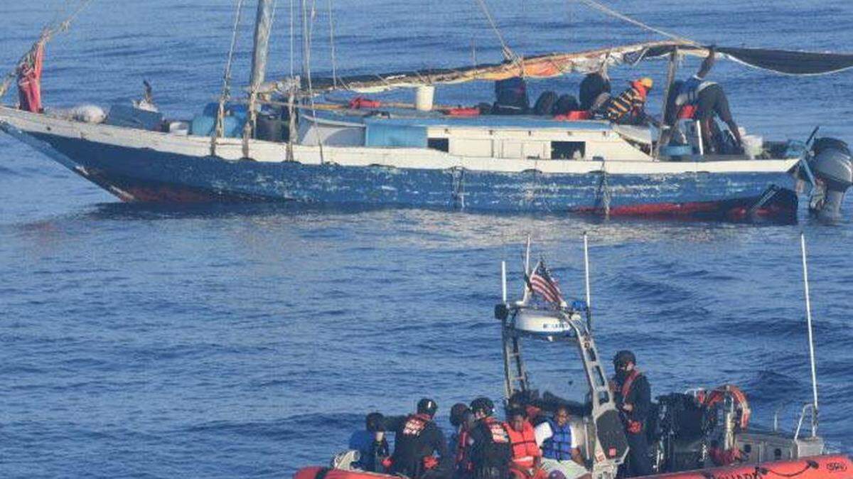 A U.S. Coast Guard boat takes Haitian citizens away from an overloaded sailboat about 17 miles northeast of Punta de Maisi, Cuba, Saturday, April 9, 2022. The 89 people were returned to Haiti on Tuesday, April 12, 2022.