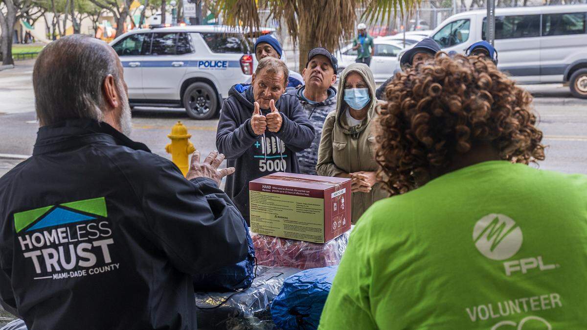 Miami-Dade County Homeless Trust Chairman Ronald L. Book, left, and Darlyne Jean-Charles, Florida Power and Light’s community specialist, distribute items — including gloves, coats, sleeping bags, hand warmers, thermal socks and blankets — for Miami outreach teams to pass out to those who refuse shelter ahead of the cold-weather advisory in effect from 10 p.m. Saturday until 10 a.m Sunday. The distribution was conducted at the Stephen P. Clark Center in downtown Miami on Saturday, January 31, 2026. FPL donated the items.