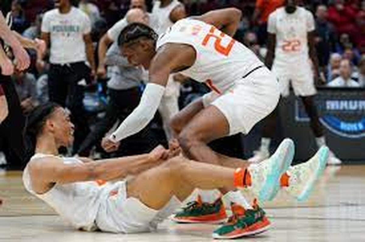 Miami Hurricanes player Isaiah Wong (on floor) is congratulated by Kameron McGusty after making a shot and being fouled during Friday night’s 70-56 Sweet 16 victory over Iowa State in Chicago.