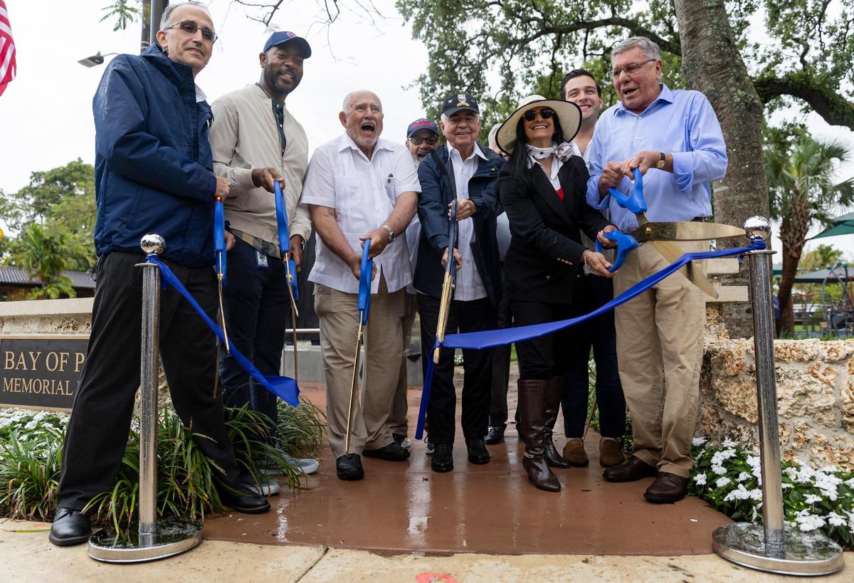 District 4 Commissioner Manolo Reyes, far-right, cuts a ribbon during a commemoration event at the Bay of Pigs Memorial Park on Wednesday, April 12, 2023, in Miami, Fla. Reyes unveiled a new monument to honor the Cubans who participated in the Bay of Pigs Invasion and showed improvements made to the park.