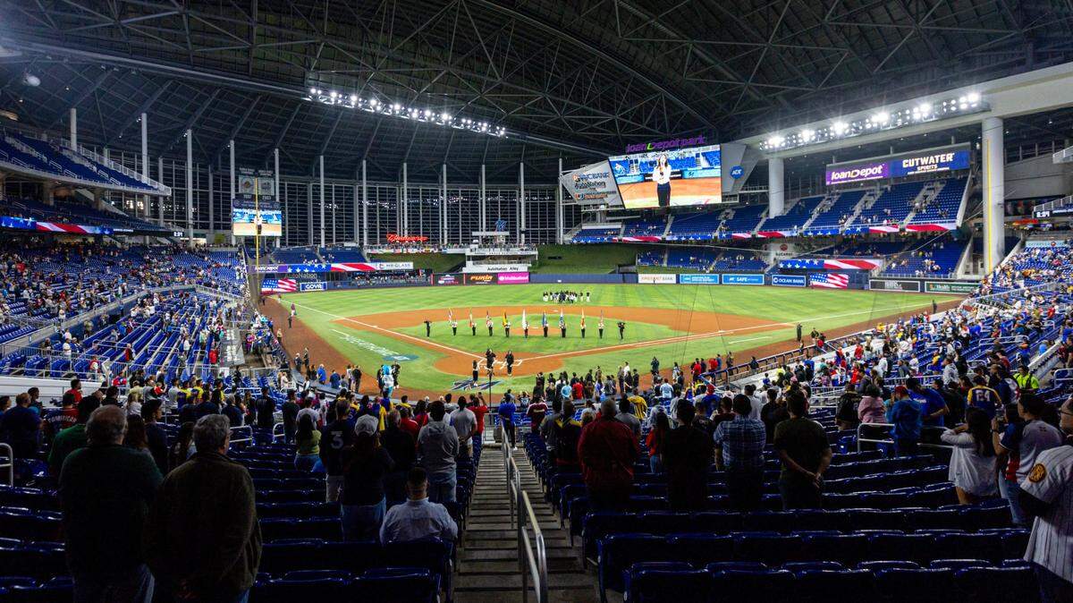 Fans stand for during a flag ceremony before the first inning of a Caribbean Series baseball game between Venezuela and Dominican Republic at loanDepot park in Miami, Florida, on Thursday, February 1, 2024.