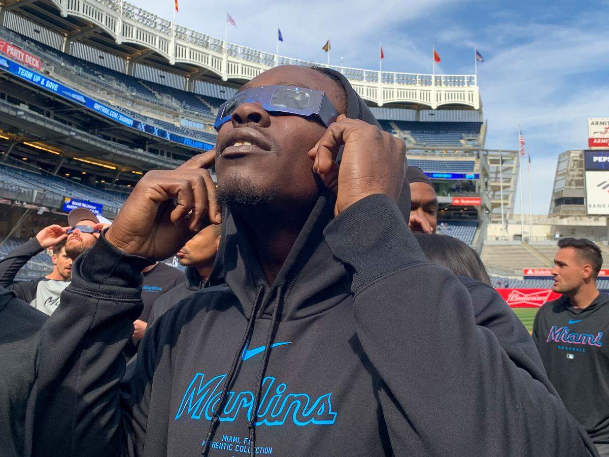 El jardinero de los Marlins Jazz Chisholm Jr. observa el eclipse solar en el Yankee Stadium en Nueva York, el 8 de abril de 2024.