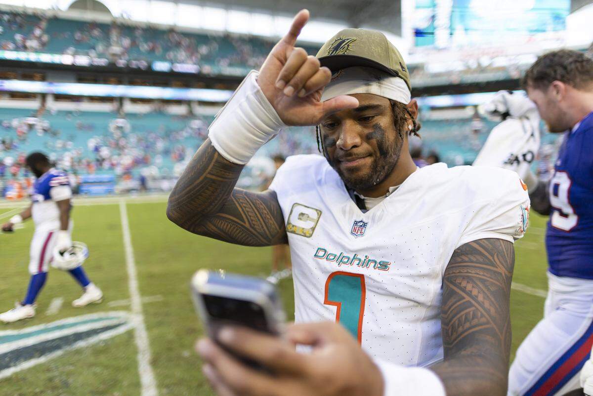 Miami Dolphins quarterback Tua Tagovailoa (1) records a video on the field after defeating the Buffalo Bills in their NFL game at Hard Rock Stadium on Sunday, Nov. 9, 2025, in Miami Gardens, Fla.