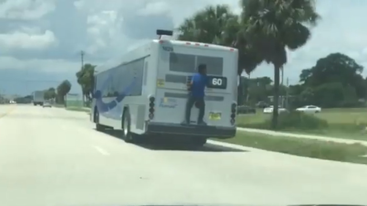 Screenshot of man hanging off bus in Broward