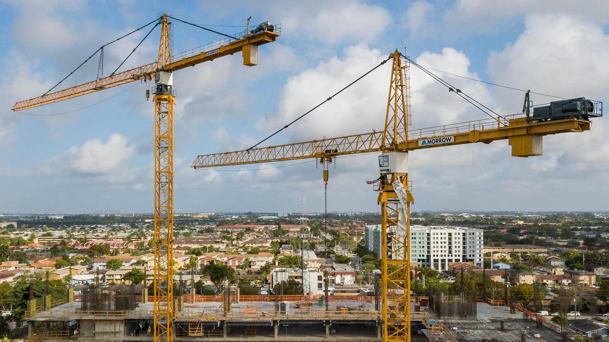 A protester stands inside a construction crane where he attached a U.S. flag and a banner near Florida International University in Sweetwater, Florida on Monday, Feb. 18, 2019. President Donald Trump is scheduled to host a rally at the school in the afternoon.