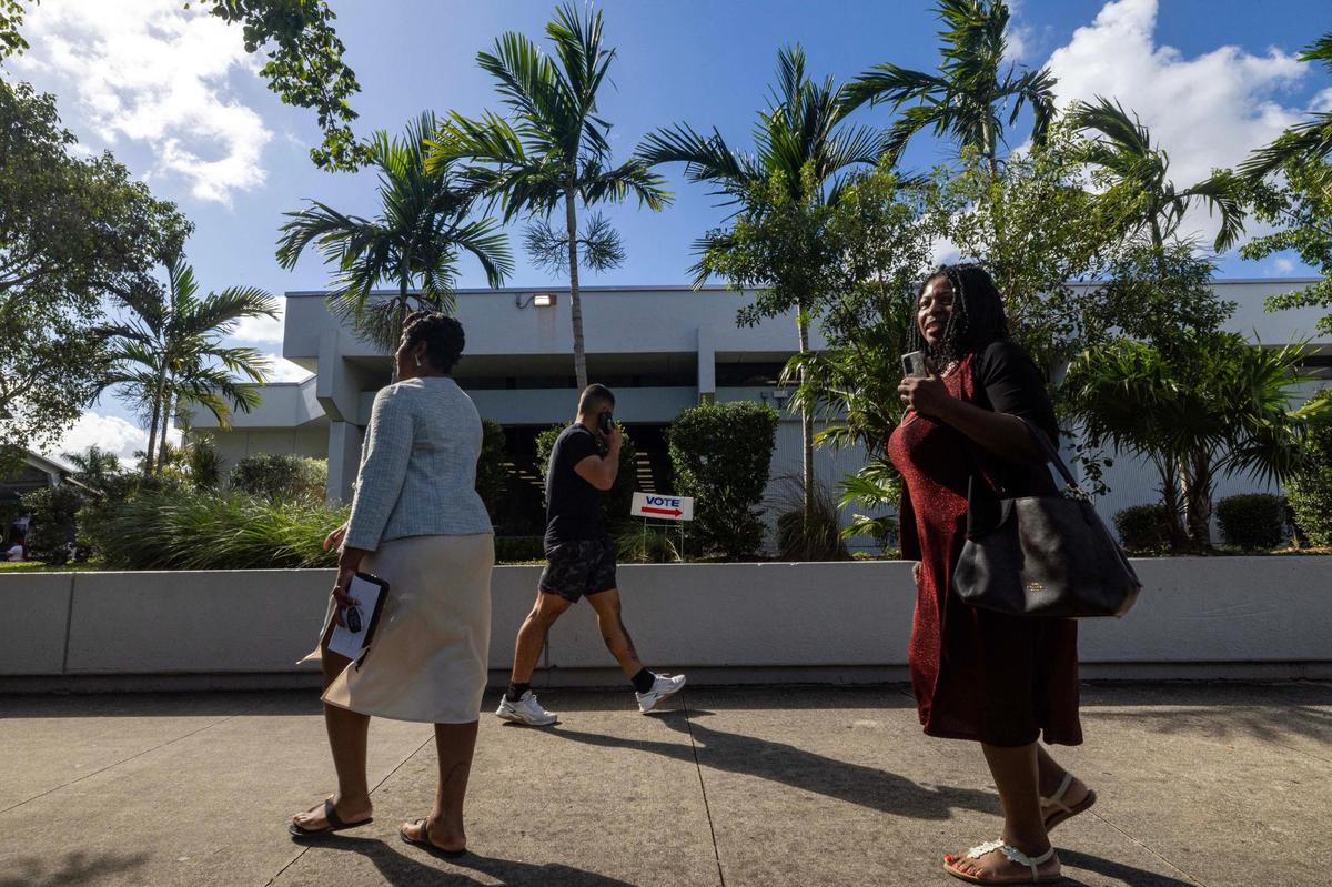 People walk outside of North Dade Regional Library during the last day of early voting on Sunday, Nov. 3, 2024, in Miami Gardens, Fla.