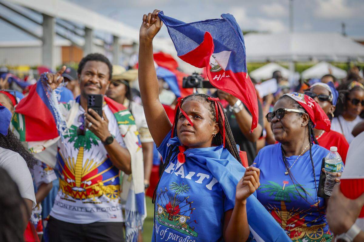 Zanyi Eloi dances and waves the Haitian flag along with others during live stage performances at the 28th Annual Haitian Compas Festival at The NoMI Village celebrating Haitian Flag Day, in North Miami, Florida  on Saturday, May 16, 2026.