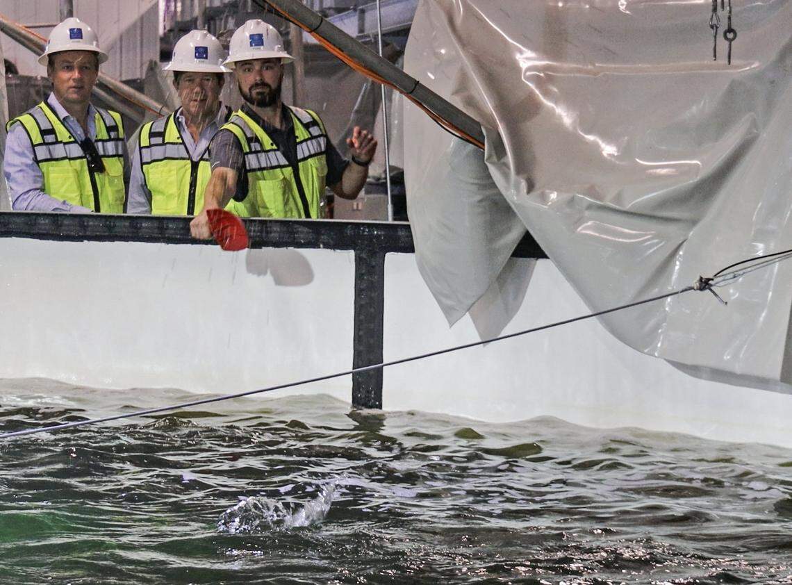 CEO Johan Andreassen, left, observes Ryan Rubino, right, feed a tank of salmon at Atlantic Sapphire, one of the world’s largest land-based salmon farms, that is under development in the Homestead area where 2.5 million salmon have been born at the facility and will complete Phrase 1 in July, 2020.