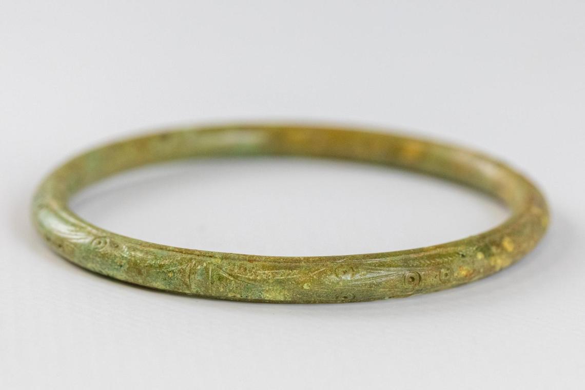 Metal bracelets with decorative designs were found in graves where bones had been destroyed.