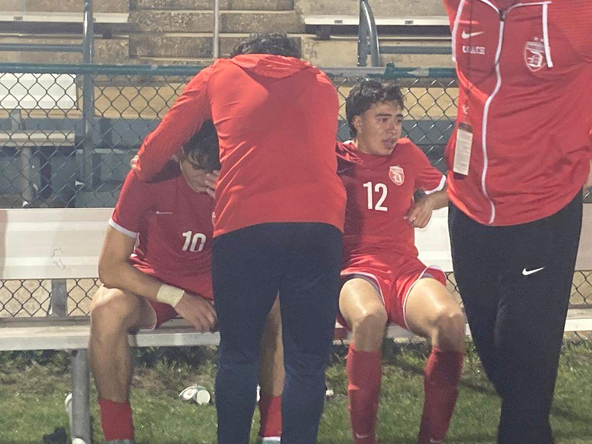 Doral boys soccer team coaches console Yitzhak Calatrava (left) and Daniel Albertos (right) on the bench after the Firebirds lost to Winter Garden West Orange in a Class 7A state semifinal at Spec Martin Stadium in DeLand, Fla.