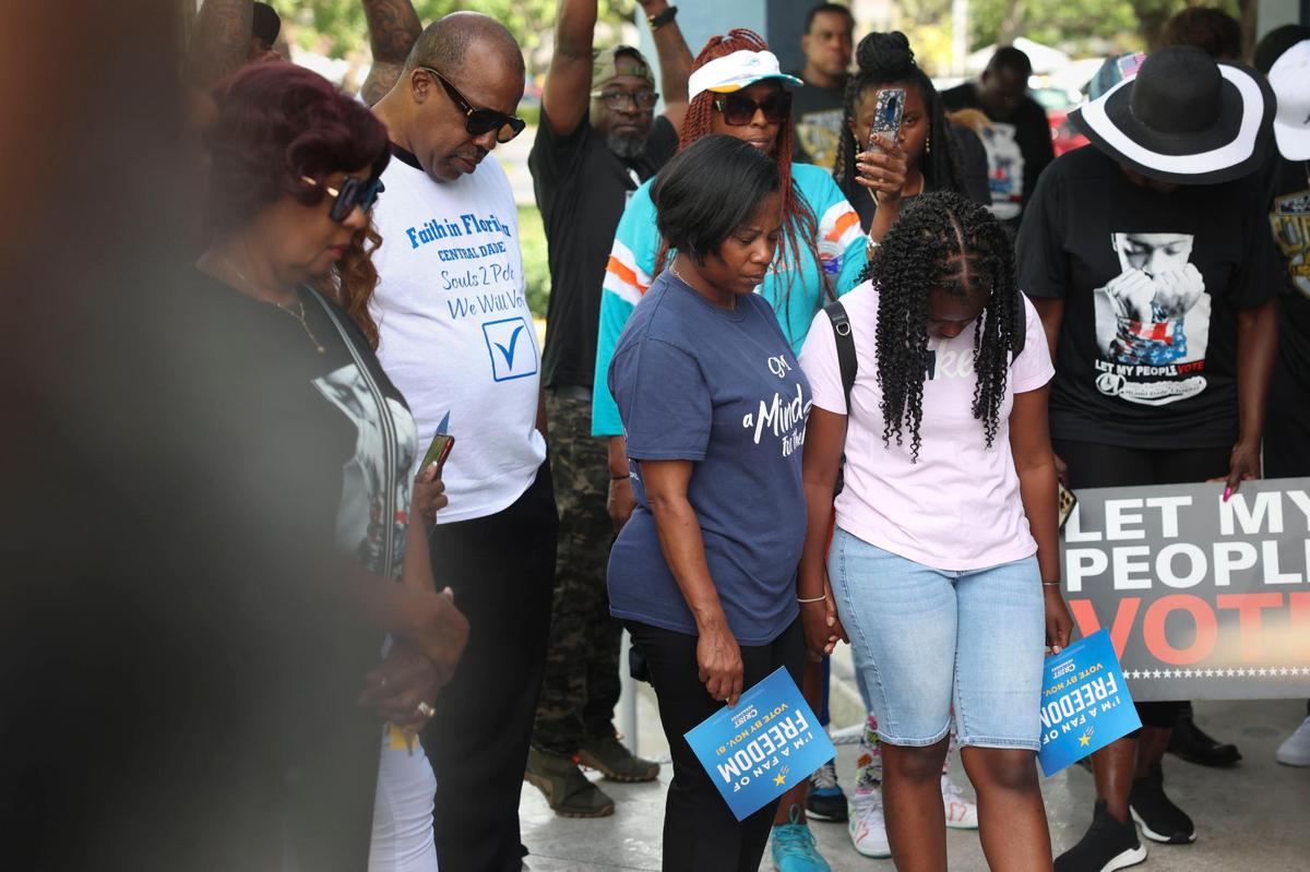 Sheneaqua Ferguson, center, and her daughter, Leah, pray together during a Souls to the Polls event on Sunday, Nov. 6, 2022, in Liberty City, Miami.