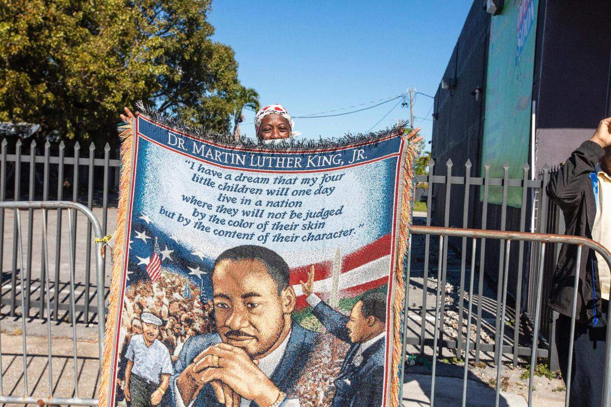 Diana Miguel at the Dr. Martin Luther King Jr. Celebration showcases an image of King and an excerpt from his ‘I Have a Dream’ speech at the annual King Holiday Parade in Miami on Monday, Jan. 16, 2023.