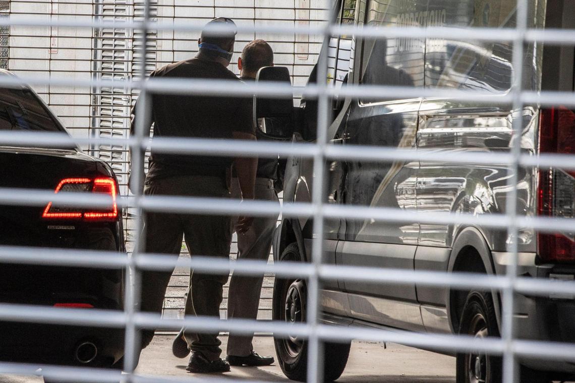 Police officers escort Miami-Dade Commissioner Joe Martinez into the Miami-Dade Turner Guilford Knight Correctional Center in Doral on Tuesday morning, Aug. 30, 2022.