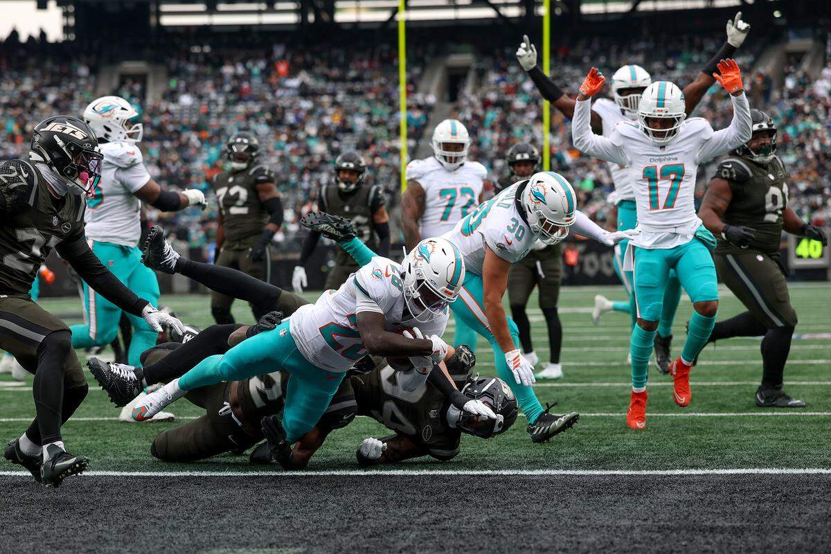 EAST RUTHERFORD, NEW JERSEY - DECEMBER 07: De'Von Achane #28 of the Miami Dolphins carries the ball for a touchdown against the New York Jets during the first quarter at MetLife Stadium on December 07, 2025 in East Rutherford, New Jersey. (Photo by Kenneth Richmond/Getty Images)