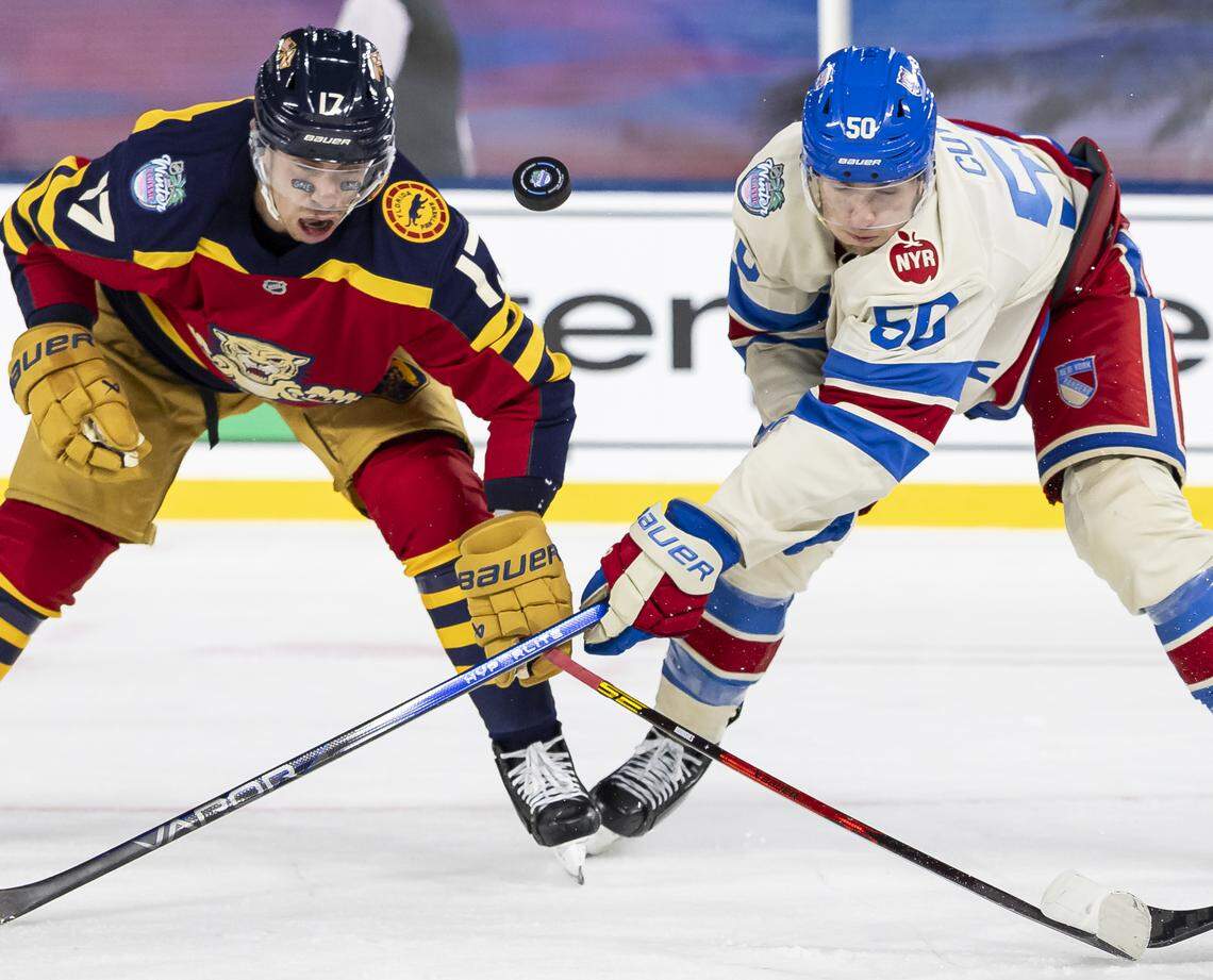 Florida Panthers center Evan Rodrigues (17) and New York Rangers left wing Will Cuylle (50) compete for the puck in the third period of their Winter Classic outdoor hockey game at loanDepot park on Friday, Jan. 2, 2026, in Miami, Fla.